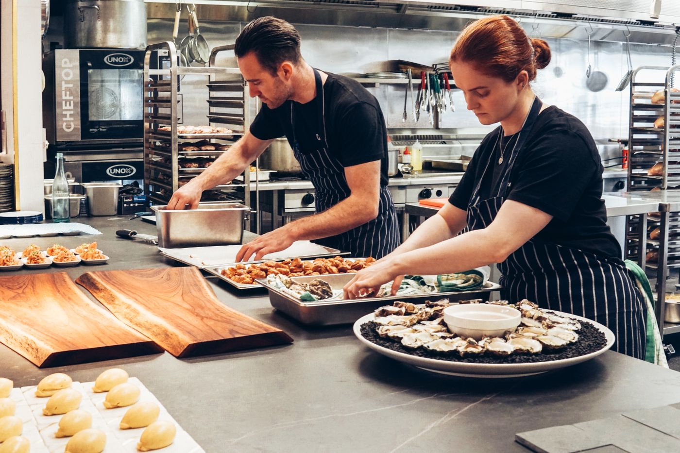 Cuisiniers dressant des assiettes en cuisine